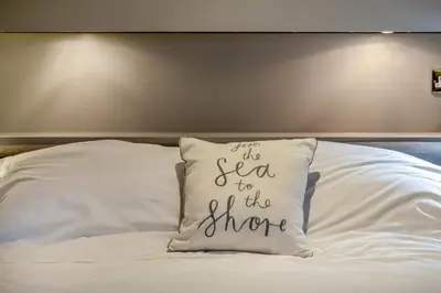 a pillow that says the sea to the shore on a bed at 2 Bed in Tywardreath oc-d34709 in Tywardreath