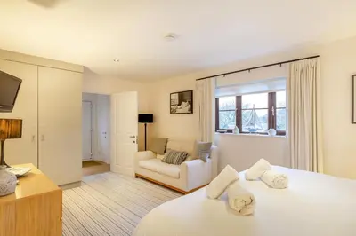 a bedroom with a white bed and a couch at 2 Bed in Tywardreath oc-d34709 in Tywardreath