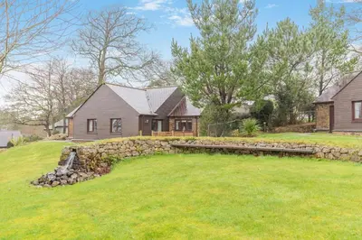 a yard with a stone wall and a house at 2 Bed in Tywardreath oc-d34709 in Tywardreath