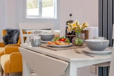 a white dining room table with plates of food on it at 1 Bed in Newquay oc-l28083 in Newquay