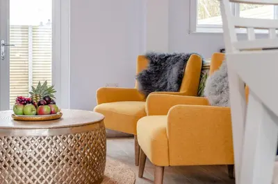 a living room with orange chairs and a bowl of fruit on a table at 1 Bed in Newquay oc-l28083 in Newquay