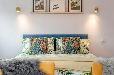 a bed with a blue head board with pillows at 1 Bed in Newquay oc-l28083 in Newquay