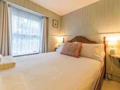 a bedroom with a large white bed with a window at Holiday Home Zion by Interhome in Gorran Haven