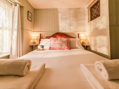 a bedroom with a large white bed with a red pillow at Holiday Home Zion by Interhome in Gorran Haven