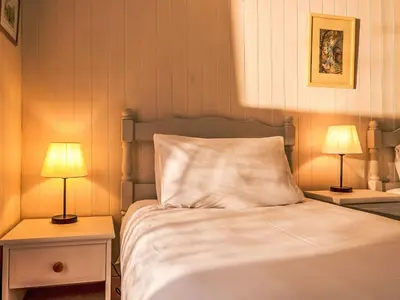 a bedroom with a bed with two lamps on tables at Holiday Home Zion by Interhome in Gorran Haven
