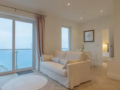 a living room with a couch and a large window at Apartment No-4 Ocean Heights by Interhome in Mevagissey