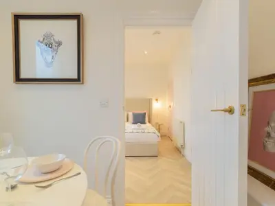 a white room with a bed and a table and a room at Apartment No-4 Ocean Heights by Interhome in Mevagissey