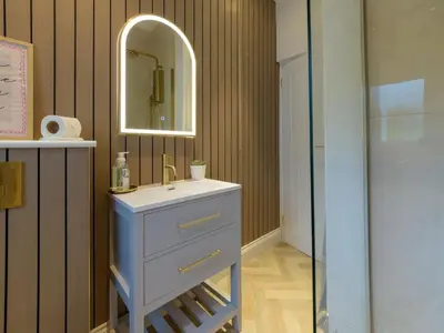 a bathroom with a blue sink and a mirror at Apartment No-4 Ocean Heights by Interhome in Mevagissey