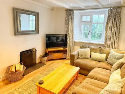 a living room with a couch and a television at Cornwall Coastal Cottage - Beautiful & Stunning in Perranporth