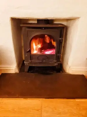 a fireplace with a fire in it in a room at Cornwall Coastal Cottage - Beautiful & Stunning in Perranporth