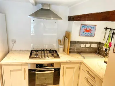 a kitchen with a stove and a counter top at Cornwall Coastal Cottage - Beautiful & Stunning in Perranporth