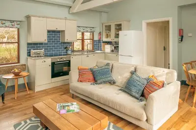 a living room with a couch and a table at Tredethick Farm Cottages in Lostwithiel