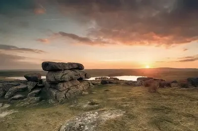 a painting of a sunset on a hill with rocks at Tredethick Farm Cottages in Lostwithiel