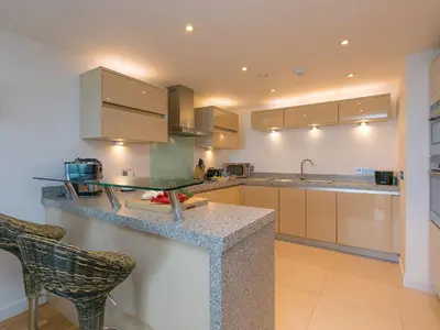 a kitchen with a counter and some chairs in it at Mid Air in St Ives