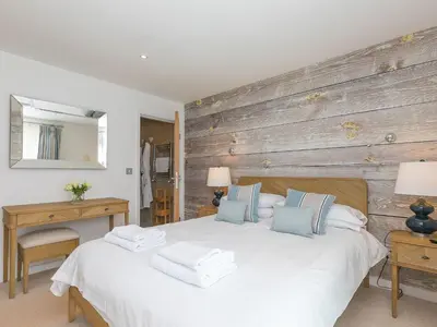 a bedroom with a white bed and a wooden wall at Mid Air in St Ives