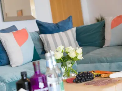 a table with a vase of flowers and wine bottles at Mid Air in St Ives