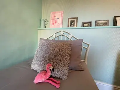 a pink toy flamingo sitting on a bed next to a pillow at Sandown 4 bedroom house St Teath in Saint Teath