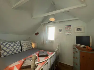 a small bedroom with a bed and a television at Sandown 4 bedroom house St Teath in Saint Teath