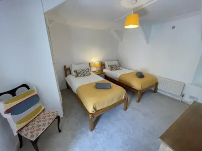 a room with two beds and a chair at The Brewhouse Boscastle Harbour in Boscastle