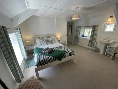 a large bedroom with a bed and a sink at The Brewhouse Boscastle Harbour in Boscastle