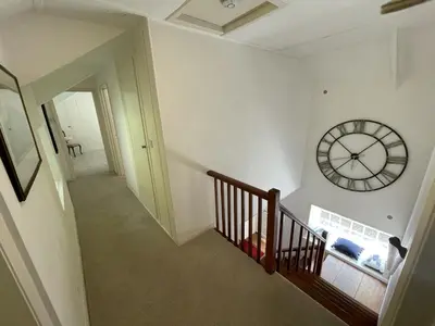 a stairway with a clock on the wall at The Brewhouse Boscastle Harbour in Boscastle