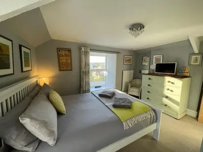 a bedroom with a bed and a dresser and a window at Sandown St Teath 3 bed sleeps 6 in Saint Teath