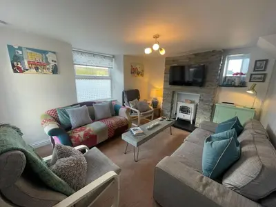 a living room with two couches and a fireplace at Sandown St Teath 3 bed sleeps 6 in Saint Teath