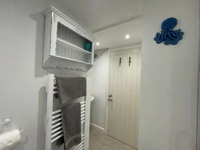 a small white room with a closet and a door at Sandown St Teath 3 bed sleeps 6 in Saint Teath