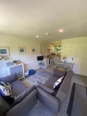 a living room with a couch and a table and a kitchen at Villa 49 Lanteglos Hotel 2 bedroom sleeps 4 in Lanteglos