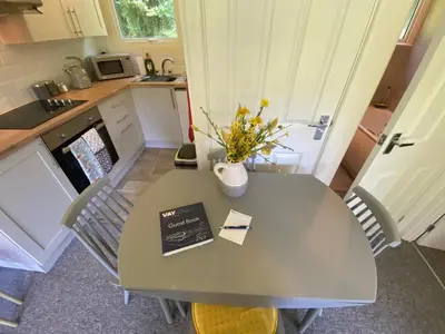 a kitchen with a table with a vase of flowers on it at Villa 49 Lanteglos Hotel 2 bedroom sleeps 4 in Lanteglos