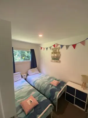 two twin beds in a room with a window at Villa 49 Lanteglos Hotel 2 bedroom sleeps 4 in Lanteglos