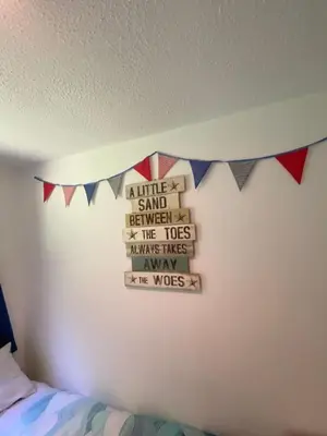 a bedroom with a wall with flags and a bed at Villa 49 Lanteglos Hotel 2 bedroom sleeps 4 in Lanteglos