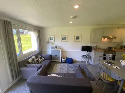 a living room with a couch and a kitchen at Villa 49 Lanteglos Hotel 2 bedroom sleeps 4 in Lanteglos