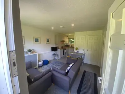 a living room with a couch and a kitchen at Villa 49 Lanteglos Hotel 2 bedroom sleeps 4 in Lanteglos