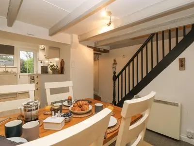 a kitchen and dining room with a table and chairs at Driftwood Cottage in Helston