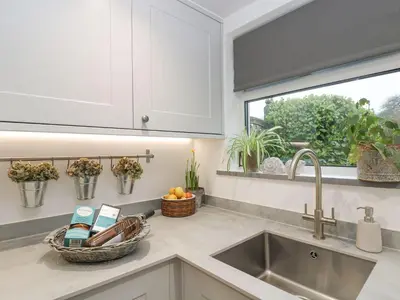 a kitchen counter with a sink and a window at Driftwood Cottage in Helston