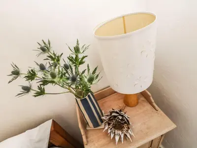 a table with a vase and a plant on it at Driftwood Cottage in Helston