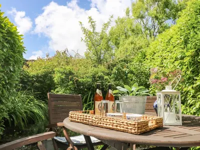 a picnic table with a basket of food on it at Driftwood Cottage in Helston