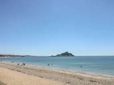 a beach with a group of people in the water at Driftwood Cottage in Helston