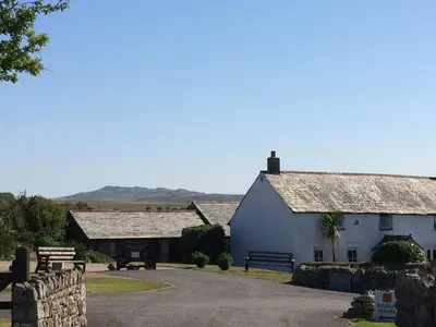 a couple of buildings with a bench in front of them at Barn Cottage in Saint Breward
