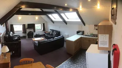a living room and kitchen in a house with skylights at Barn Cottage in Saint Breward