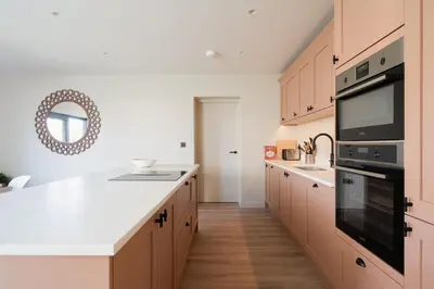 a kitchen with wooden cabinets and a black appliance at Allora in Carbis Bay