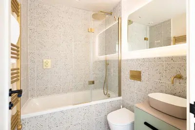 a bathroom with a tub and a sink and a toilet at Allora in Carbis Bay