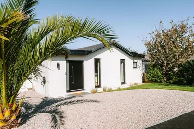 a white house with a palm tree in front of it at Allora in Carbis Bay