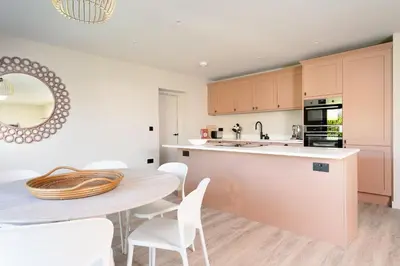 a kitchen with a table and chairs and a table and a counter at Allora in Carbis Bay