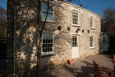 a brick building with a white door and windows at Pencreek in Kea