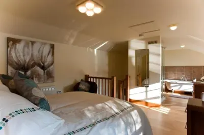 a bedroom with a large bed and a bathroom at Pencreek in Kea