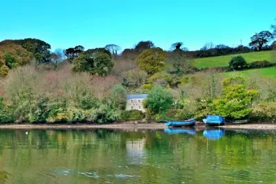 three boats sitting on the shore of a lake at Pencreek in Kea