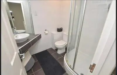 a bathroom with a toilet and a sink and a shower at Seabrook Lodge in Newquay
