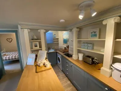 a large kitchen with a counter and a sink at Praxis Trebarwith Strand in Treknow